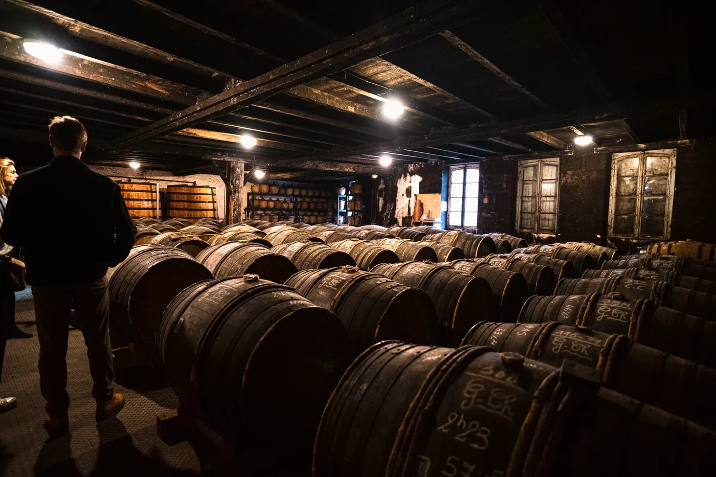 Hands resting on aged oak barrel